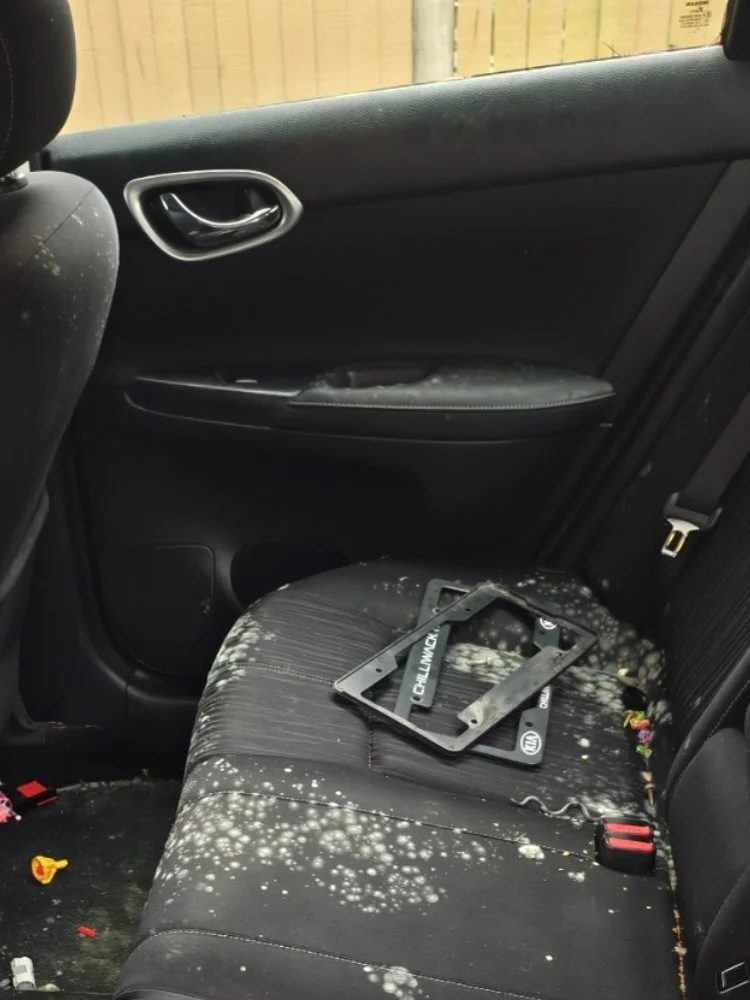 Rideshare sedan rear seat with spilled-drink mold before Downtown Miami cleaning