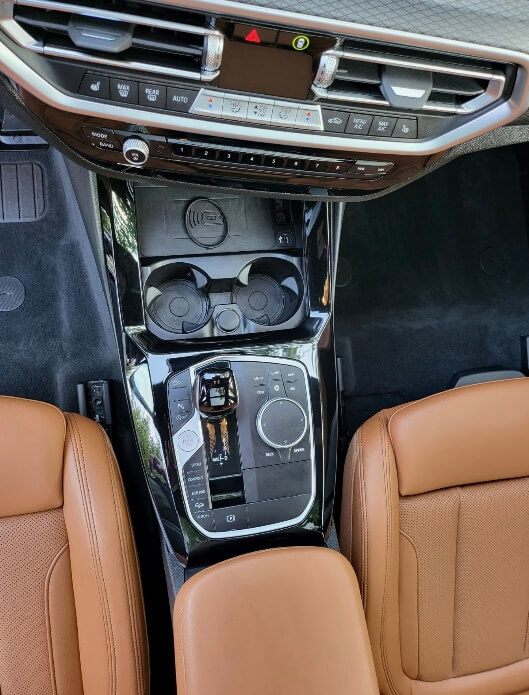 BMW interior after detailing with a clean console, cup holders and carpet
