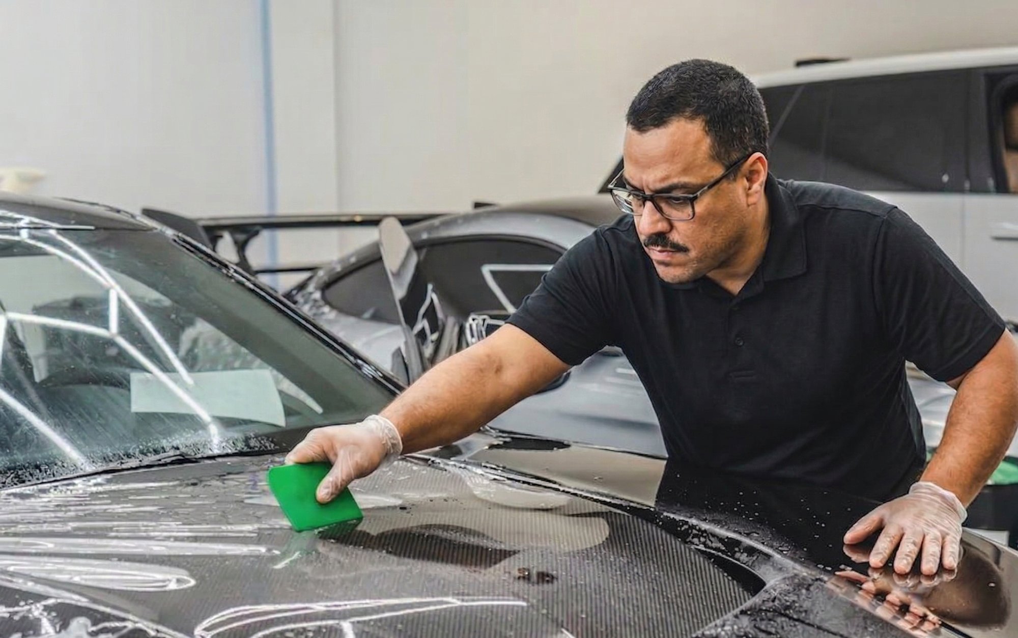 DShine Details XPEL certified technician installing paint protection film in South Florida — Partial Front from $1,200, Full Front from $2,500